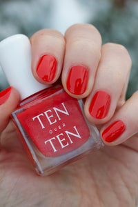 Bright Red Nail Polish on Nails with Bottle