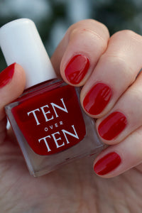 Classic Red Nail Polish on Nails with Bottle